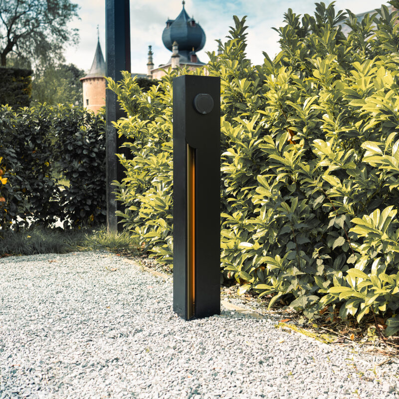 Veton Two charging station on a gravel path at Cleydael Golf & Country Club, hedge and castle turret behind.